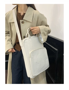 Dettaglio di una borsa tote in tessuto Oxford bianco avorio con tracolla per la scuola