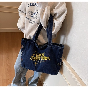 Détail du sac cabas en denim bleu avec broderie jaune Groovy Trippy Heart et motifs d'étoiles