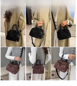Detail view of suede crossbody bags in black and brown with woven rope handles