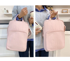 Dettaglio della borsa in nylon rosa chiaro con tasca frontale e trama in tessuto trapuntato