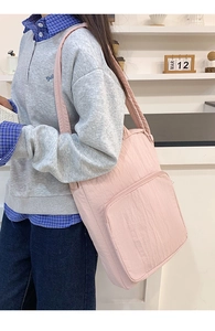 Dettaglio della borsa tote rosa in tessuto Oxford con trama stropicciata e tasca frontale a zip