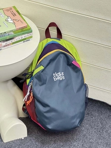 Detail of color-block waterproof backpack showing durable fabric and side mesh pocket