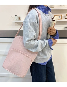 Dettaglio della borsa tote in nylon trapuntato rosa chiaro con tasca frontale a zip