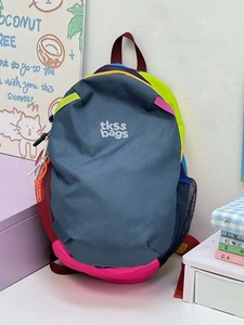 Close-up of color-block backpack showing tkss bags logo and vibrant nylon fabric textures