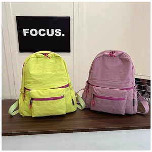 Detailed view of lightweight nylon backpacks with multi-pocket design in green and pink