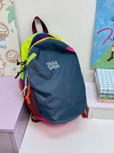 Detail view of water-resistant nylon backpack with vibrant color-block panels and zippers