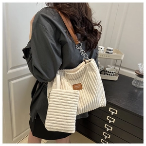 Detail of corduroy tote bag with chain strap and matching small pouch in cream white