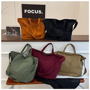 Collection of large canvas tote bags in five colors with top handles and crossbody straps