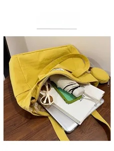 Top view of yellow canvas tote bag showing spacious interior with laptop and books