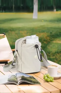 Dettaglio della borsa porta borraccia in nylon beige con tracolla regolabile e cordino