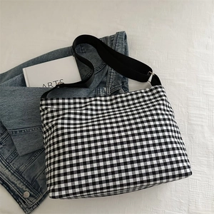 Close-up of black and white gingham canvas bucket bag with adjustable wide strap