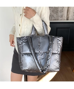 Close-up of metallic silver quilted tote bag with large padded compartments and glossy texture