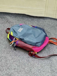 Flat lay of colorful multi-tone backpack with breathable mesh side pockets and dual straps