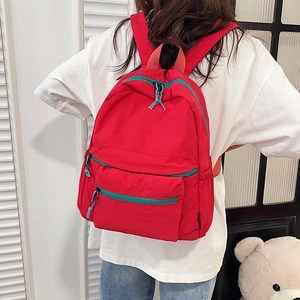Minimalist red nylon backpack with high capacity and contrasting blue pullers