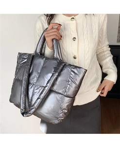 Detailed view of silver padded tote bag with metallic quilted fabric and shoulder strap