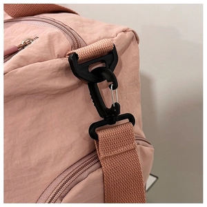Close-up of pink nylon gym bag detailing durable plastic hooks and reinforced stitching