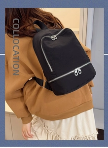 Sac à dos minimaliste en nylon noir avec détails zippés porté par le mannequin