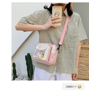 Vue détaillée d'un sac à bandoulière en toile rose avec fenêtre transparente et lapin en peluche