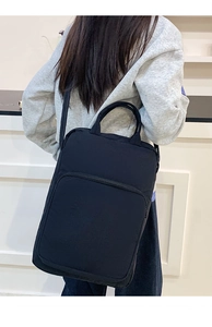 Dettaglio della borsa tote nera in tessuto Oxford con doppi manici e tracolla regolabile