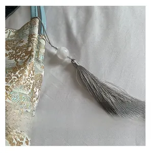 Detail of landscape embroidery on high-capacity tote bag with silver tassel
