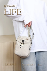 Dettaglio borsa a tracolla in nylon crema per bottiglia d'acqua con coulisse e cinturino