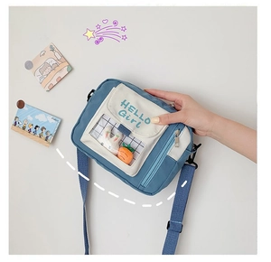 Détail d'un sac bandoulière en toile avec fenêtre transparente et décor de lapin en peluche