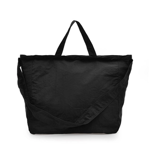 Minimalist large black canvas tote bag with dual handles and adjustable shoulder strap