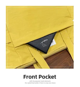 Detail view of the yellow canvas tote bag front pocket with a black notebook inside