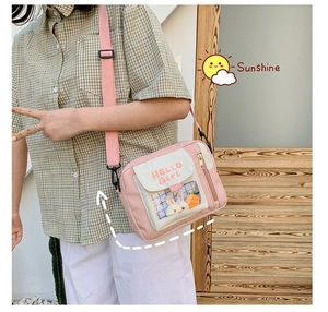 Détail du sac en toile rose et blanc avec un lapin mignon dans la poche transparente