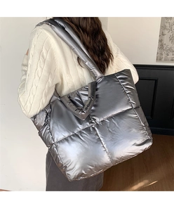 Detail of silver metallic puffer tote bag with quilted padding and shoulder strap