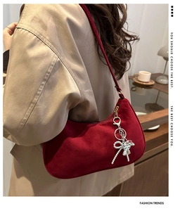 Détail du sac baguette en daim bordeaux avec pendentif nœud en perles argentées chic