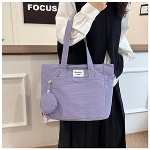 Detail view of purple nylon tote bag with front pocket and round mini coin purse attachment