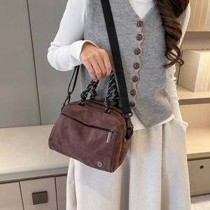 Brown suede crossbody bag with woven handle and black shoulder strap for daily commuting