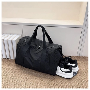 Detailed view of the large capacity black nylon travel bag featuring a separate shoe compartment