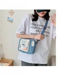 Détail du sac bandoulière en toile bleu et beige avec poche PVC et texte Hello Girl