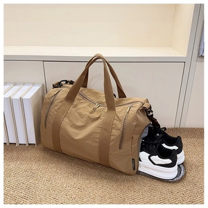 Detail showing side zipper shoe compartment of khaki nylon gym bag with sports shoes