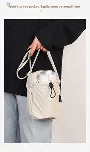 Dettaglio della borsa a tracolla in nylon con tasca frontale a coulisse per una bottiglia