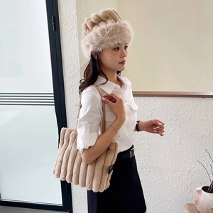 Dettaglio cappello alla pescatora in peluche marrone e borsa tote in ecopelliccia a righe
