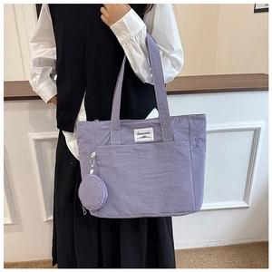 Detail view of lavender tote bag with front pocket and circular coin purse attachment