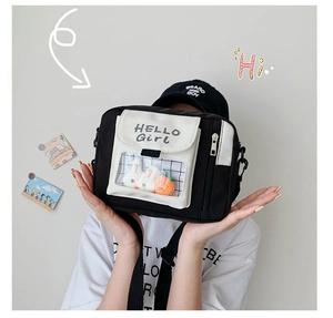 Détail du sac bandoulière en toile avec fenêtre transparente et breloques peluches