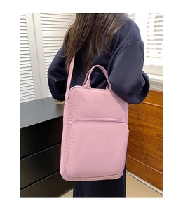 Dettaglio della borsa tote in nylon rosa chiaro con tasca a zip e tracolla regolabile