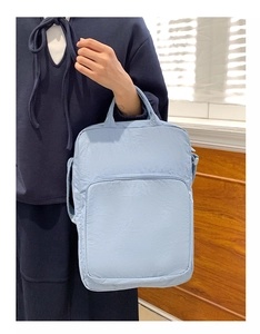 Dettaglio della borsa azzurra in tessuto Oxford con tasca a zip e trama del materiale
