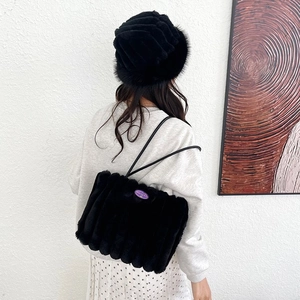 Borsa tote in ecopelliccia nera e cappello di peluche coordinato a righe eleganti