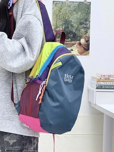 Detail of color-block water-resistant nylon backpack with side mesh pocket and zip pulls