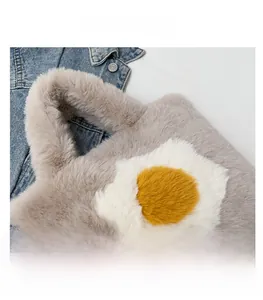 Close-up of fluffy grey plush handbag featuring a creative poached egg design detail