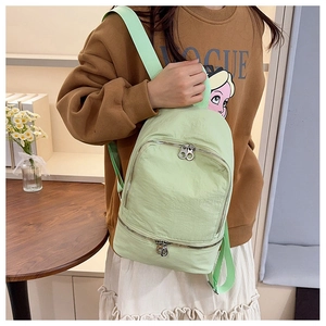 Détail du mini sac à dos en nylon vert clair avec poches à double fermeture éclair en métal