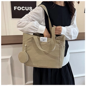Detail view of khaki large capacity tote bag with round mini coin pouch and logo label
