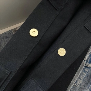 Detailed close-up of canvas bucket bag featuring magnetic gold metal closures