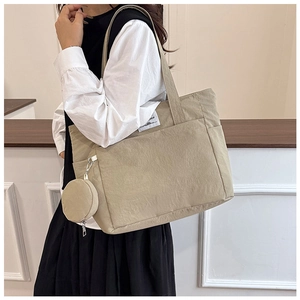 Detail of beige nylon tote bag with small round coin purse and sewn letter label
