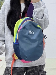 Detail of multi-color waterproof backpack featuring mesh side pockets and trendy lettering